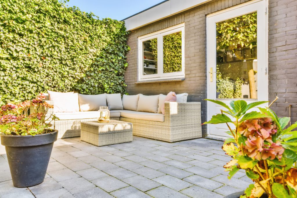 A top view of an interlocking patio made of grey stone tiles in a herringbone pattern